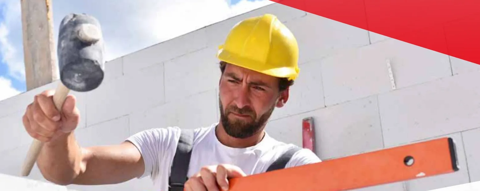 Maurer mit Wasserwaage auf der Baustelle